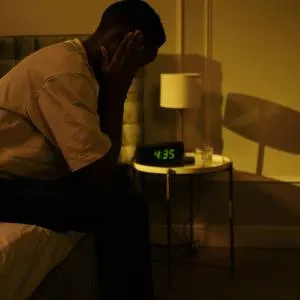 Man waking up and struggling to sleep